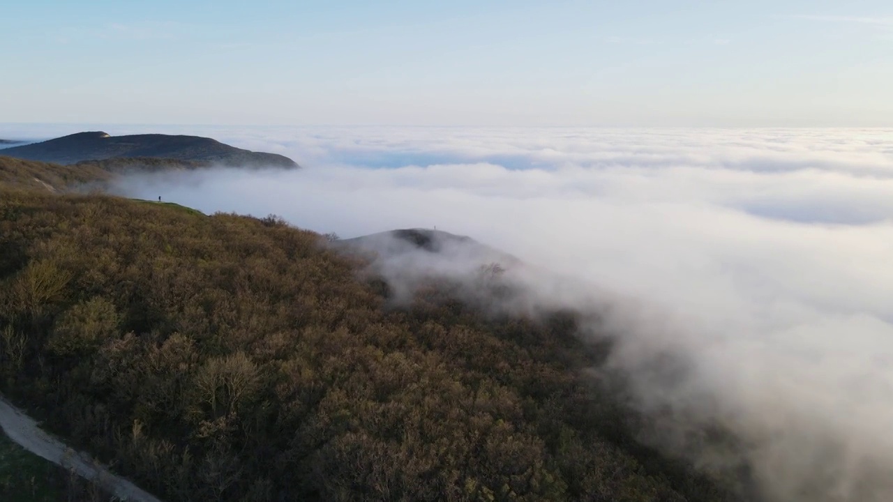 鸟瞰图，缓慢蔓延的雾和山脉与森林。多雾的天气视频素材