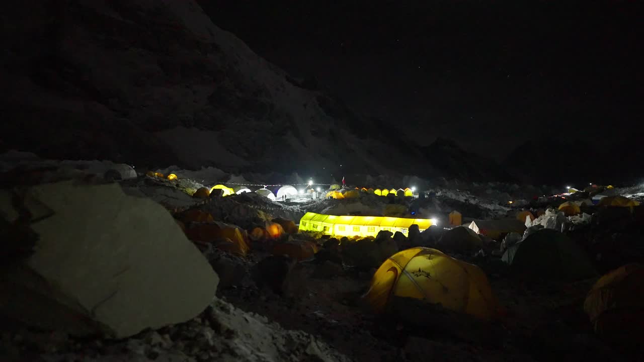 黑暗中的珠峰大本营，黄色的登山帐篷被灯光照亮视频下载