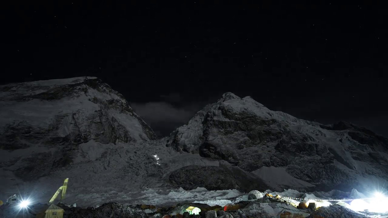 非常棒的间隔拍摄。登山运动员的灯光在星空下爬上阴影的斜坡视频下载