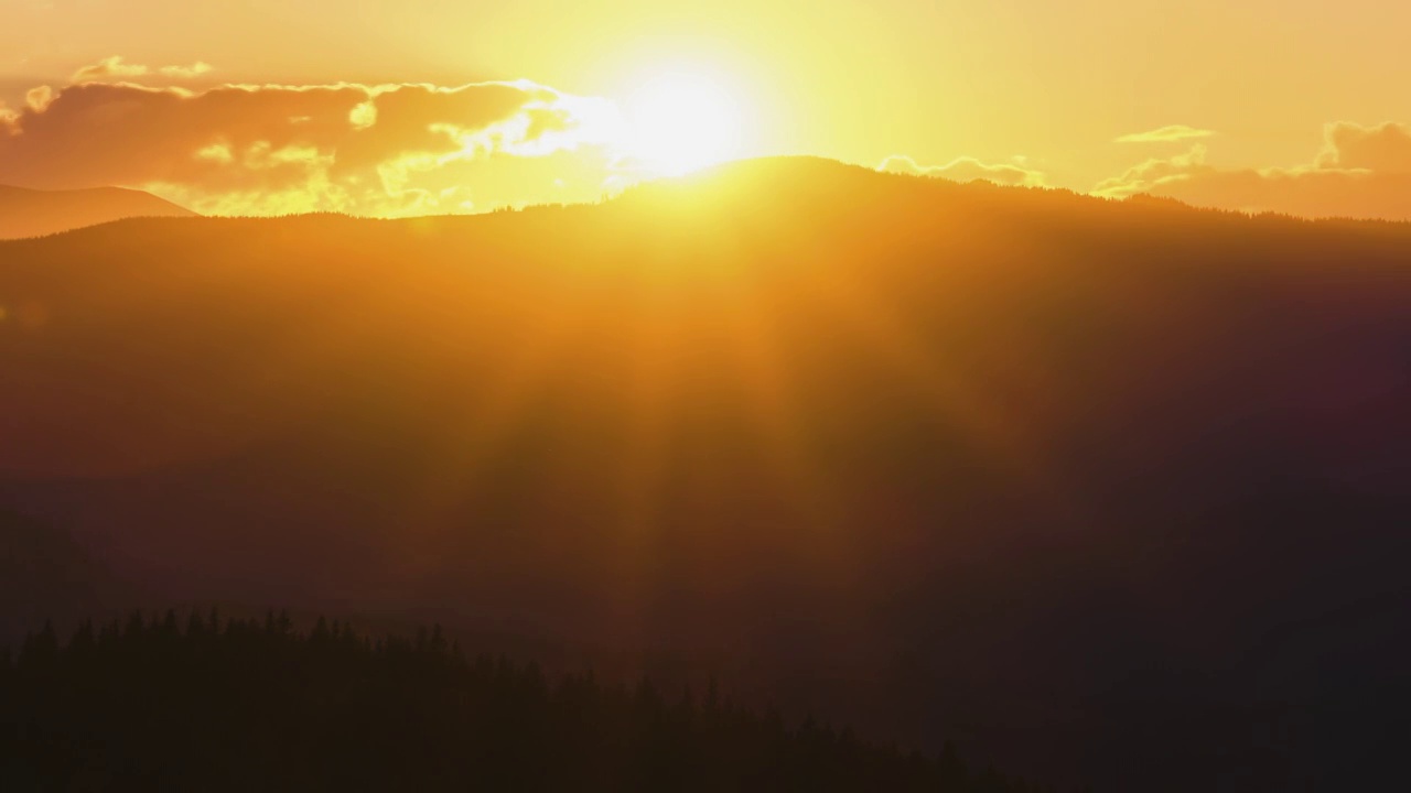 美丽的傍晚全景景观与明亮的夕阳在遥远的山峰在日落视频素材