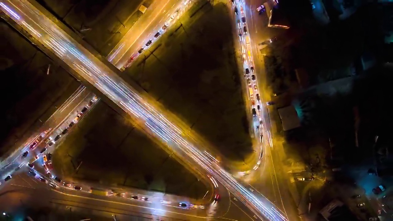 夜间快速移动的交通繁忙的十字路口鸟瞰图。城市交通的时间推移。交通高峰期，汽车尾灯模糊不清视频素材