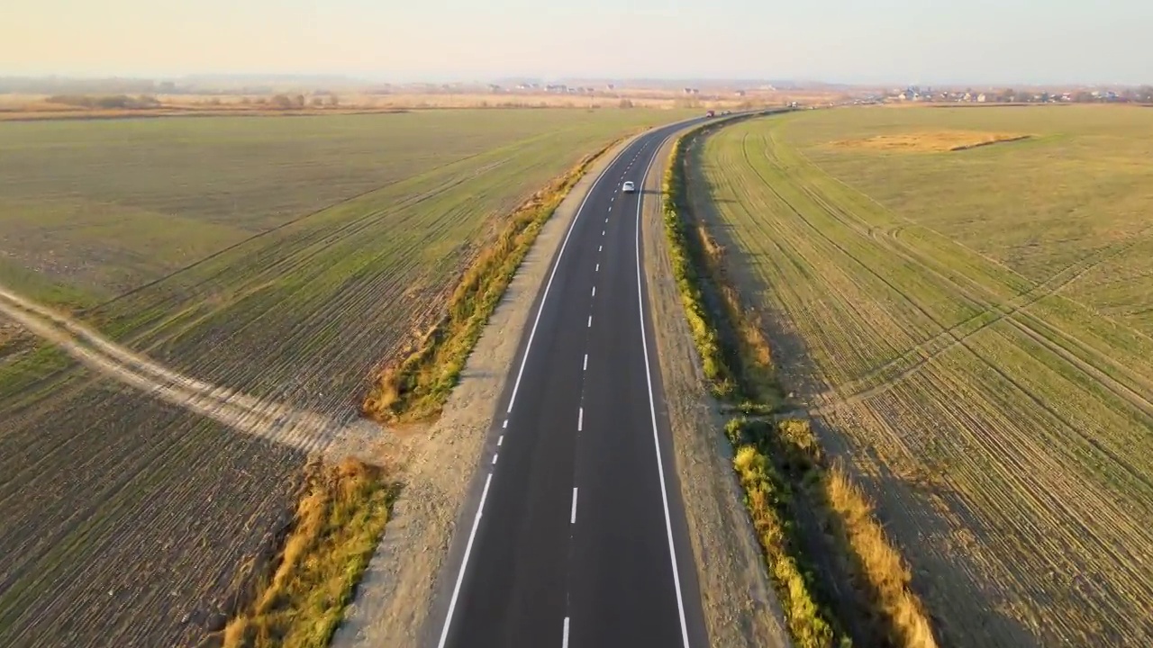 鸟瞰图的城际道路与快速行驶的汽车在日落。俯视图从无人机公路交通在晚上视频素材