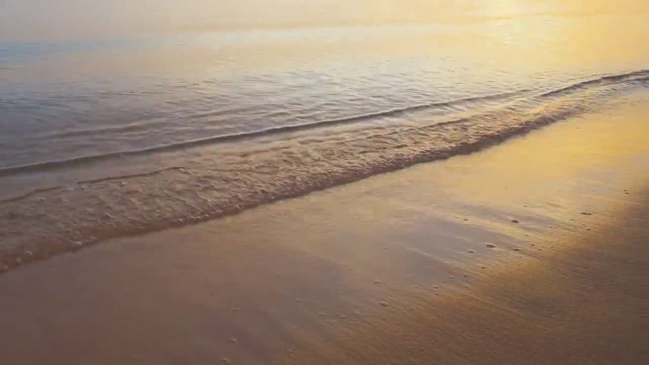 平静的海岸，在日出时，海浪拍打着沙滩视频素材