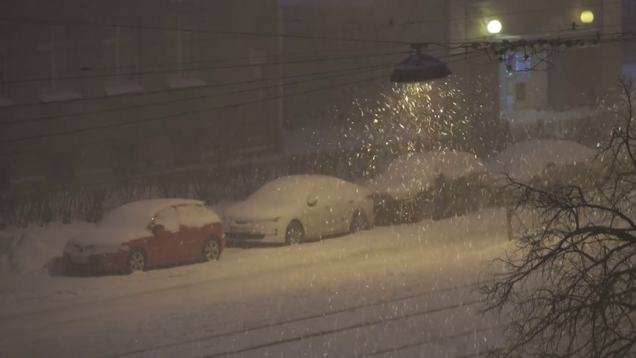 城市夜晚的雪花，街灯照亮的暴风雪，恶劣的天气，视频素材