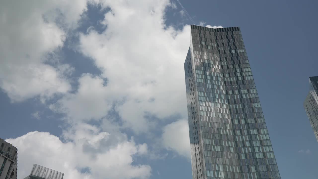 在英国兰开夏郡曼彻斯特的Deansgate，蓝天映衬下的高楼大厦视频素材