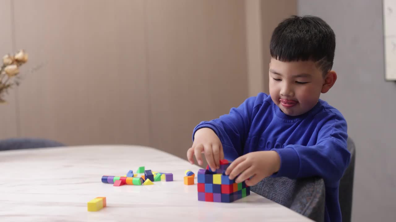 这个小男孩正在家里玩积木视频素材