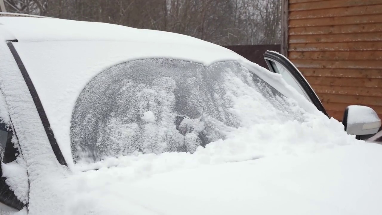 冬天，汽车刮水器会清除挡风玻璃上的雪。恶劣天气视频素材