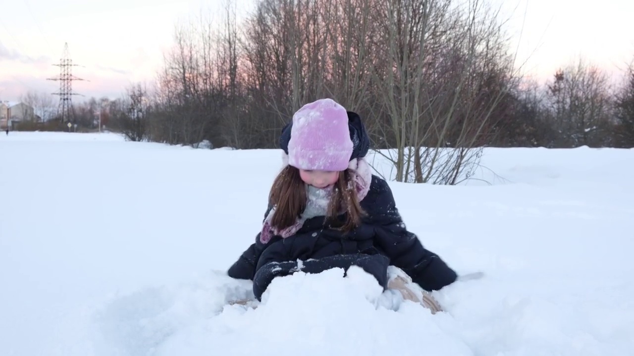 可爱的小女孩玩雪，玩得很开心。儿童冬季游戏度假概念视频素材