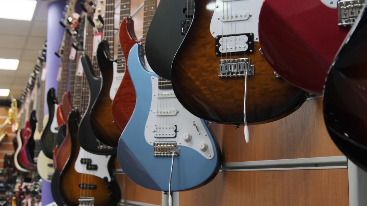商店里出售许多新款、不同颜色的电吉他视频素材