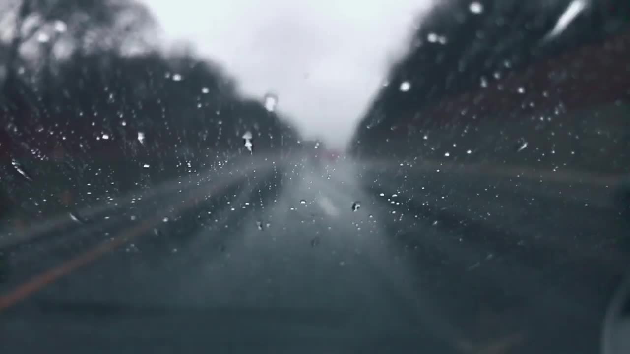 在下雨的时候开车，当雨滴向上移动汽车的后窗视频素材