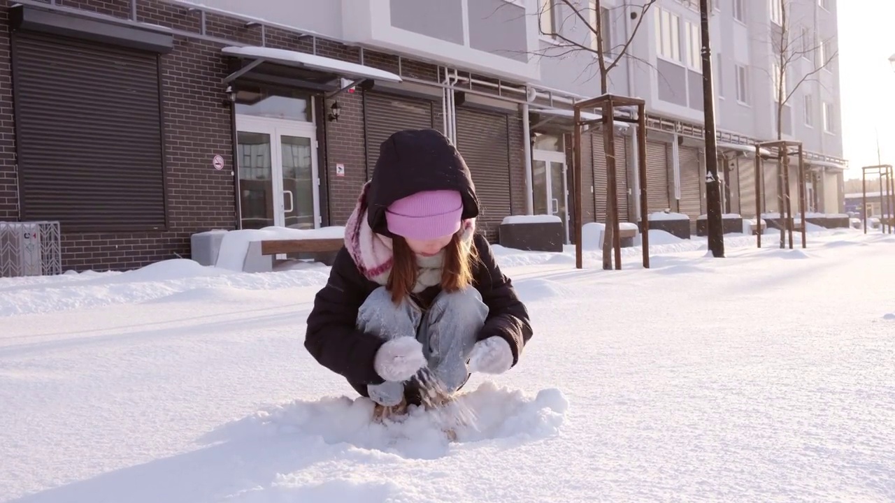 可爱的小女孩玩雪，玩得很开心。儿童冬季游戏度假概念视频素材