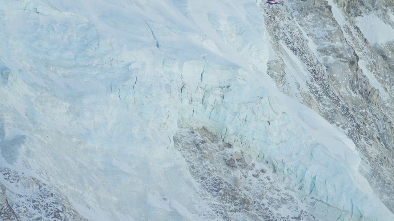 山区救生任务。救援直升机在巨大的雪冰川上高高地飞行视频下载