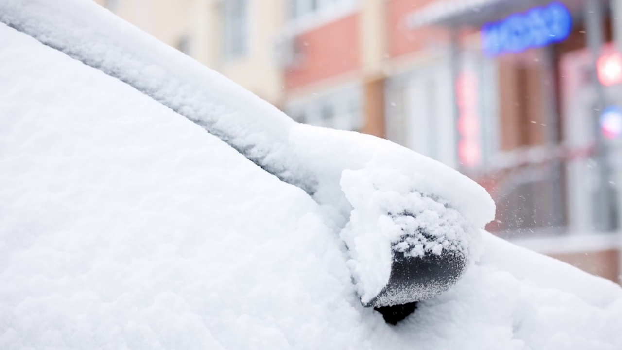 近距离的雪覆盖的汽车在冬季白天降雪，慢动作视频素材