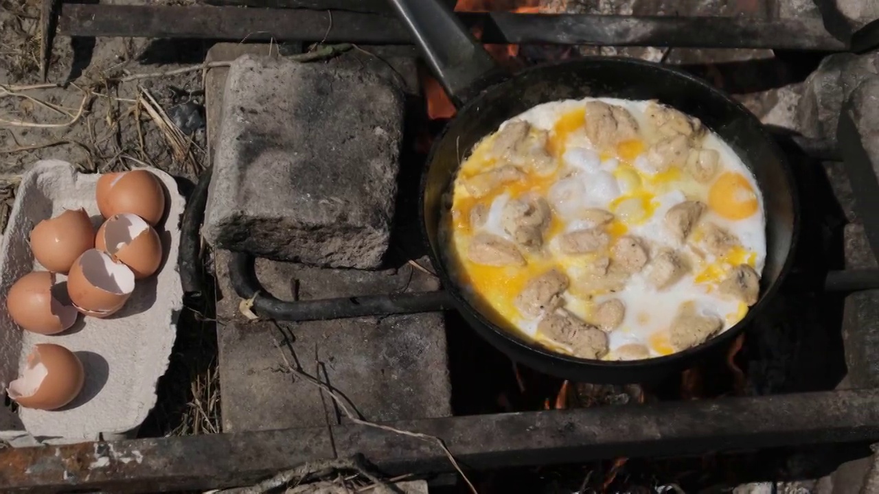 在旅游营火煎锅上用鸡肉炒蛋，自然视频素材