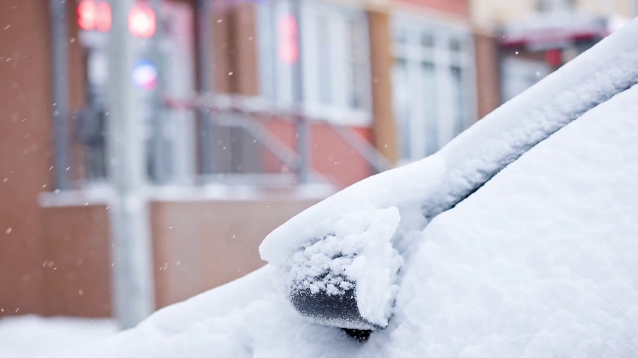 近距离的雪覆盖的汽车在冬季白天降雪，慢动作视频素材