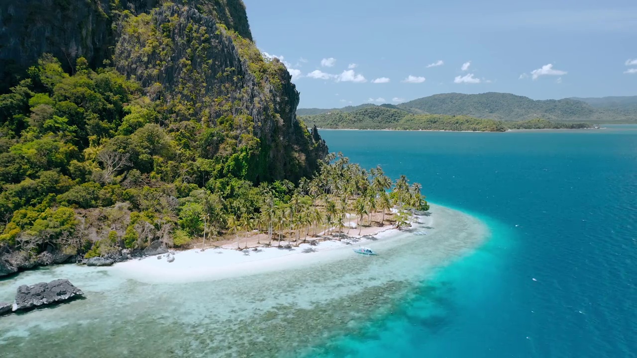 天堂般的热带沙滩Ipil海滩在pinagbuutan岛。El Nido，巴拉望岛，菲律宾。湛蓝的海水，椰子树和当地的游船在海岛跳游B视频素材