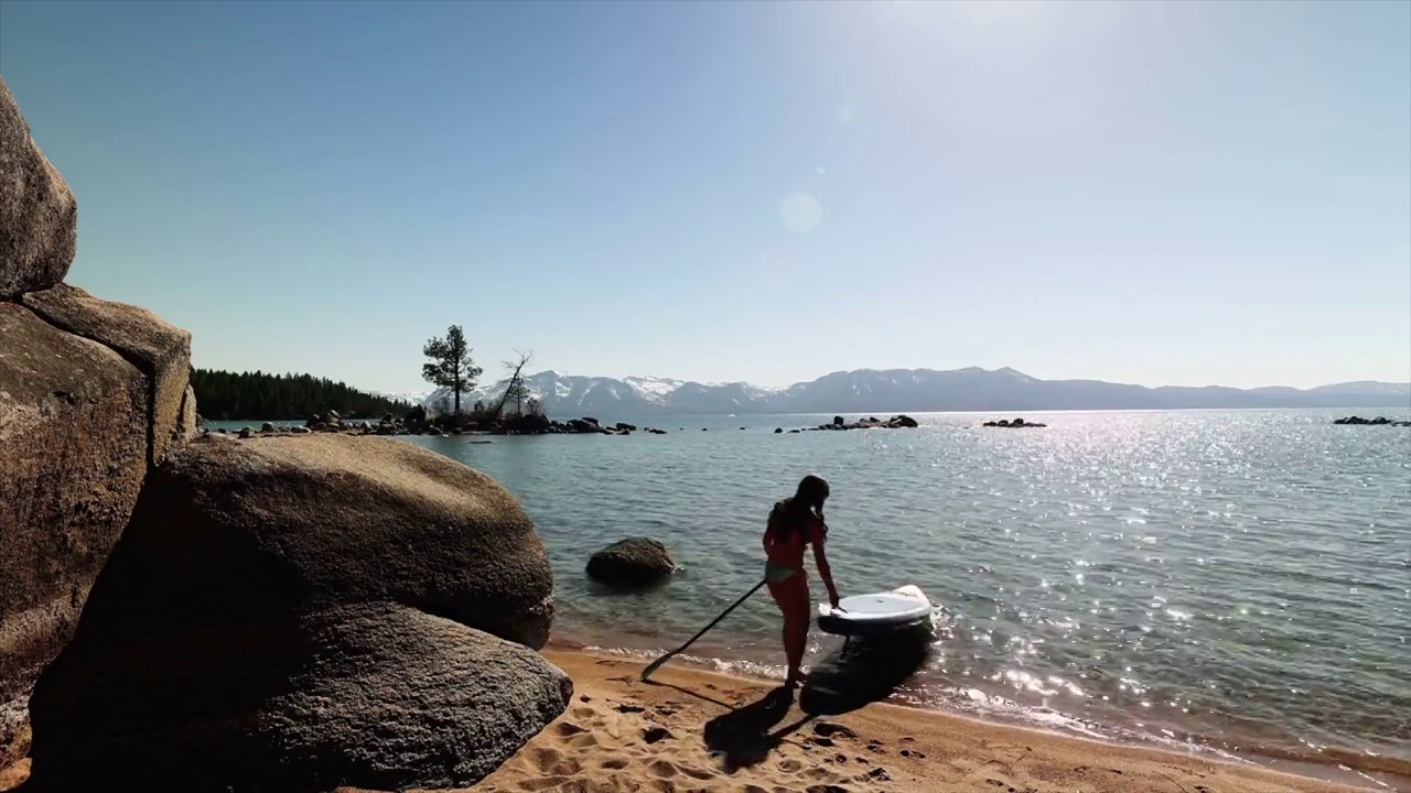 年轻美丽的女人与冲浪板在海滩股票视频视频素材