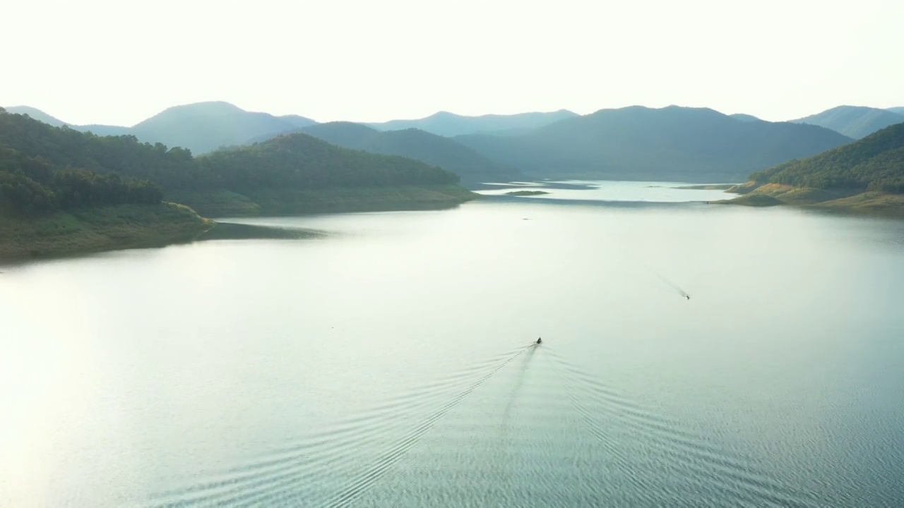 鸟瞰水库大坝内的水景和山景，游船贯穿其间，方便运输和渔猎。可再生能源与电力技术。无人机4k鸟瞰图中美丽的风景。视频素材