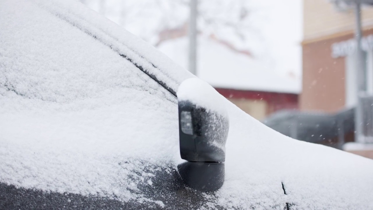 近距离的雪覆盖的汽车在冬季白天降雪，慢动作视频素材