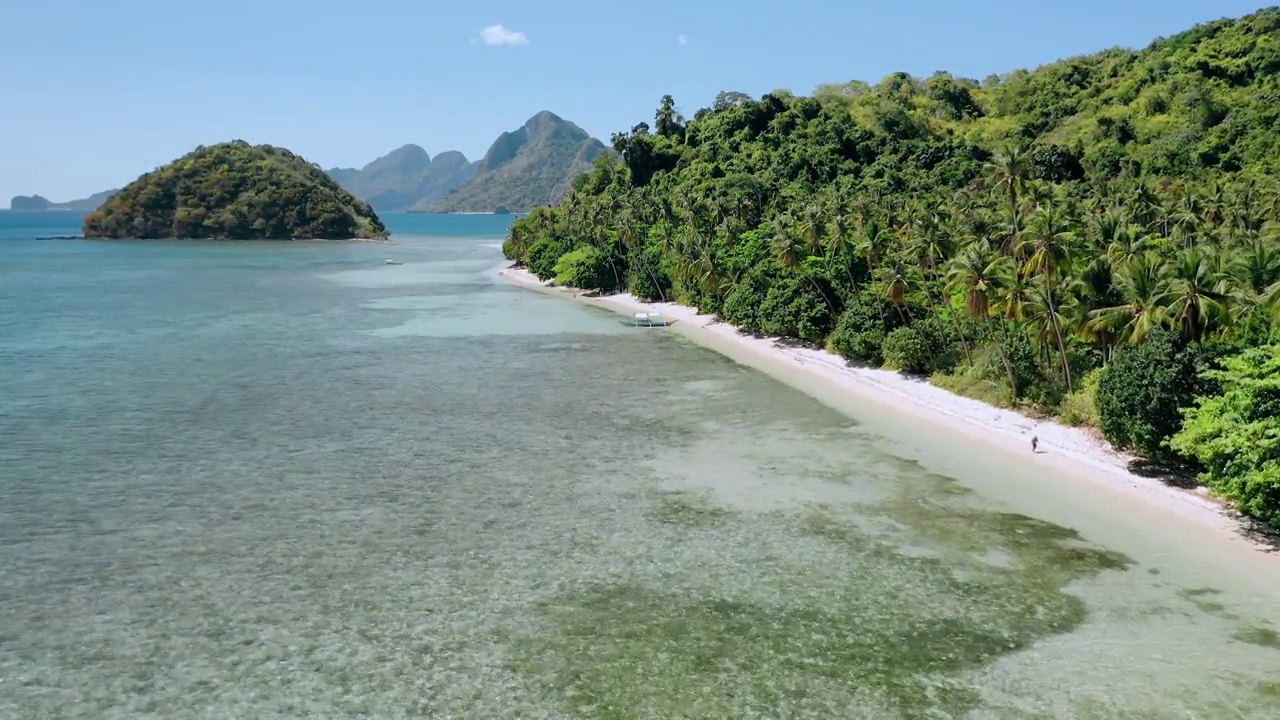 4k无人机在天堂热带海滩的浅水上空飞行，椰子树在海风中摇摆。探索菲律宾巴拉望岛的厄尔尼诺岛视频素材