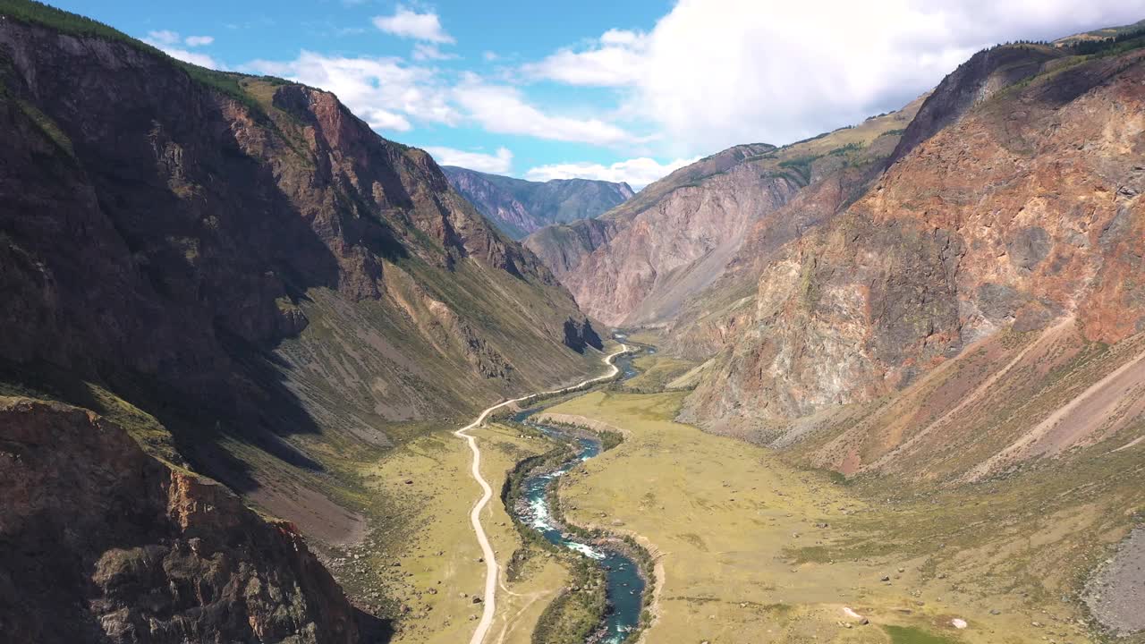 在野外野外的落基山脉，在河流峡谷附近的土路上空飞行视频素材