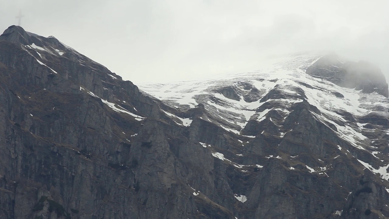 美丽的风景，山顶上仍然覆盖着积雪。天空灰蒙蒙的视频素材