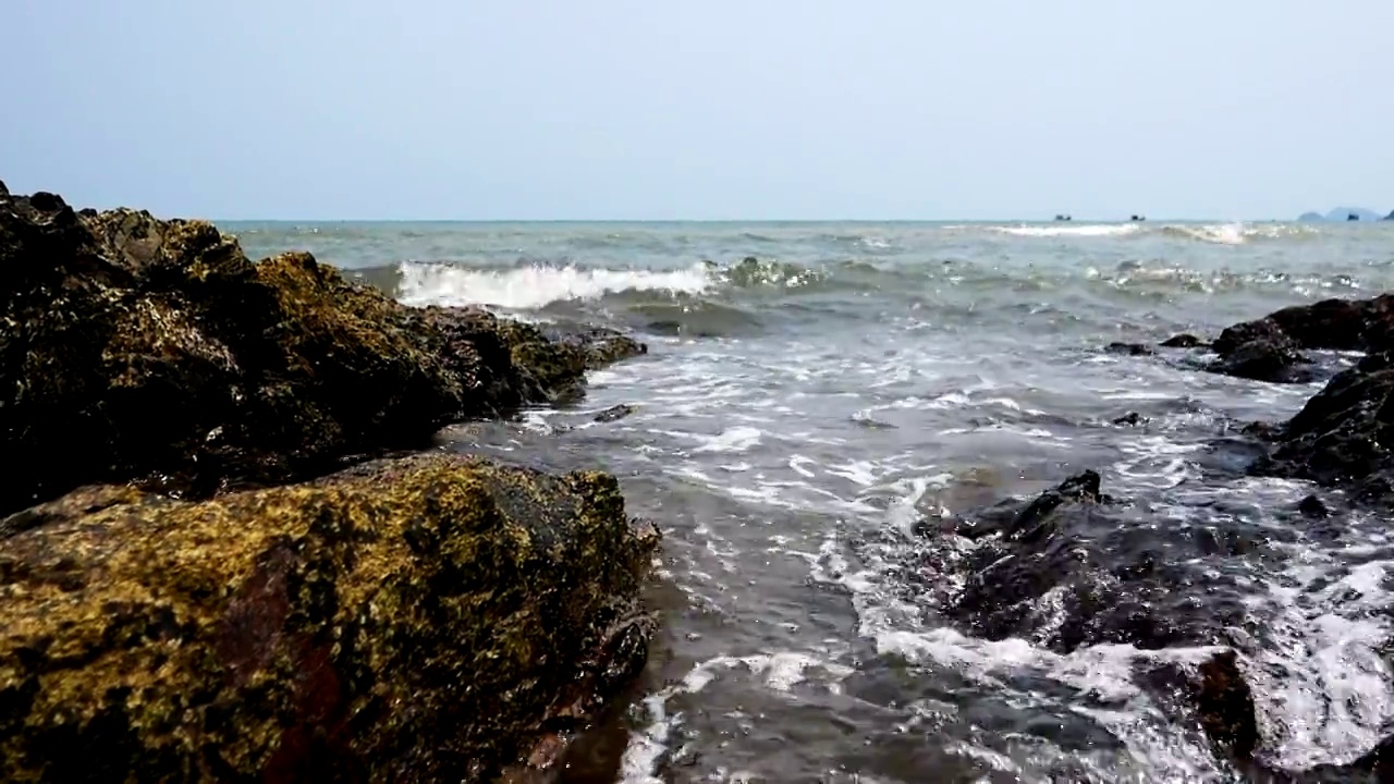 海浪轻轻地拍打着岩石。视频素材