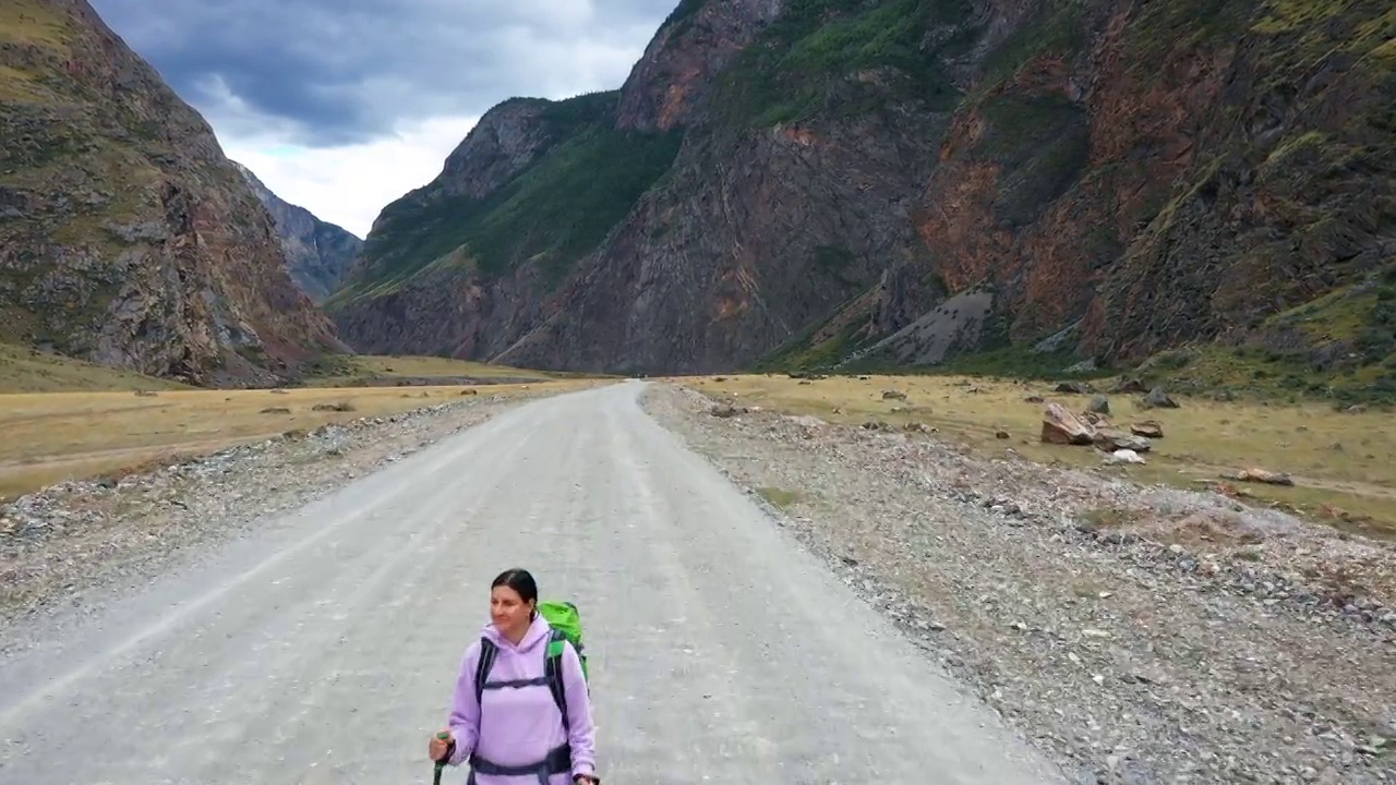 在岩石山公园的乡村公路上徒步旅行的女游客视频素材