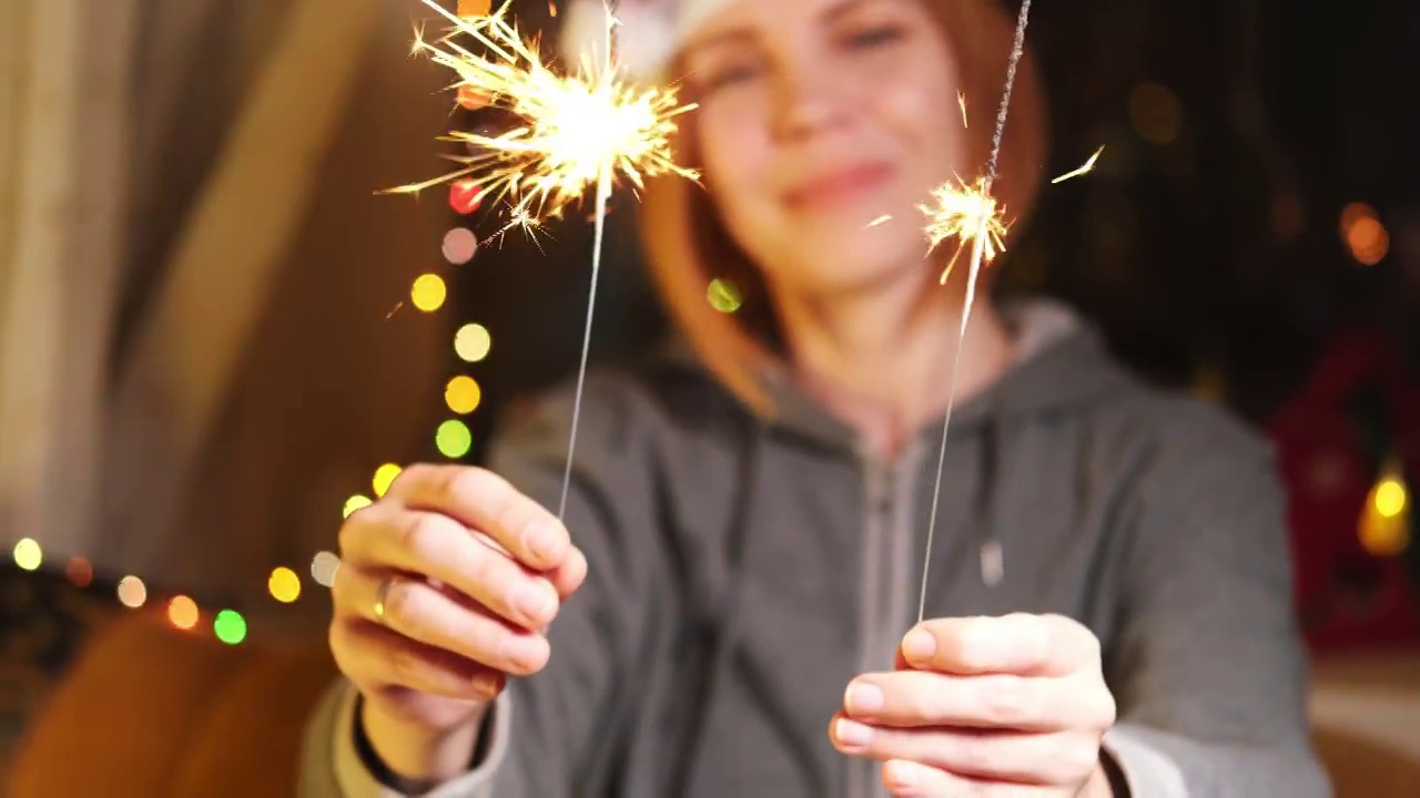 一个乐观的中年妇女手里拿着火花。新年，圣诞节的概念。视频素材