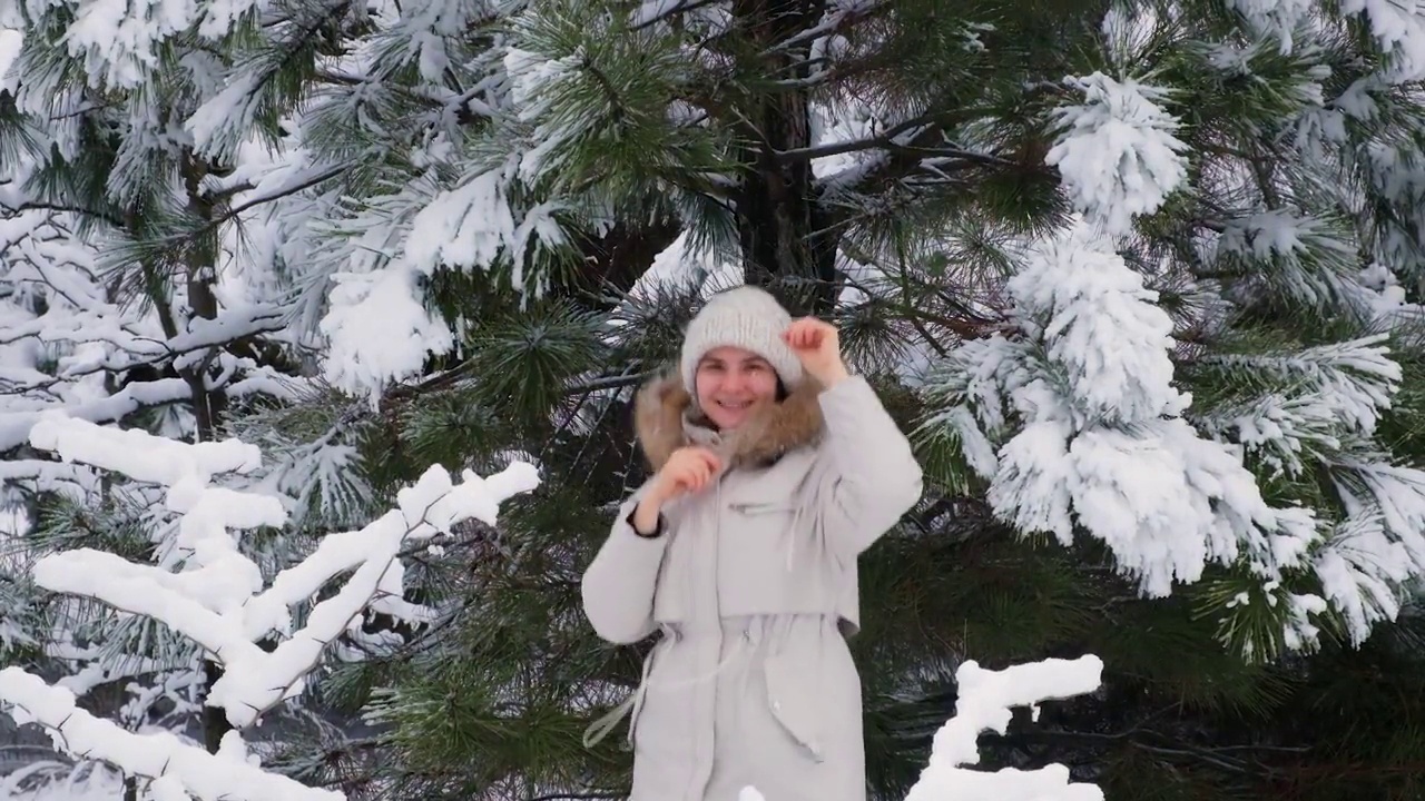 一个女人在冬天的雪原里跳跃嬉戏，雪花飞舞，慢动作视频素材