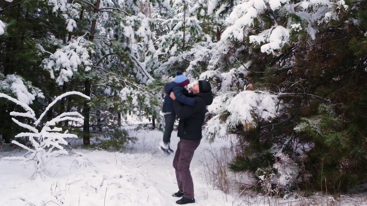 一位父亲抛下他的儿子，在冬天积雪的森林里度过时光视频素材