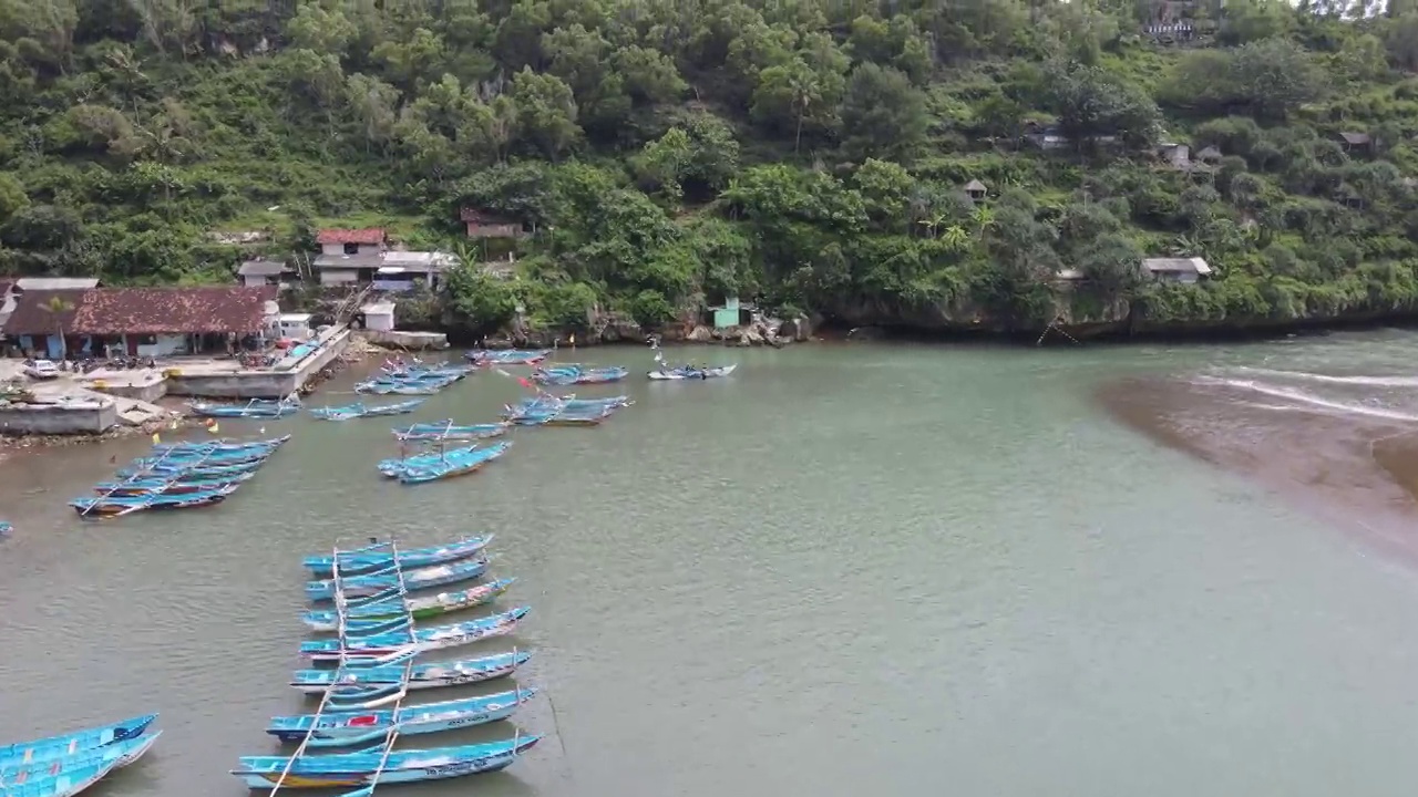 鸟瞰印尼泻湖海滩上的传统船只视频素材