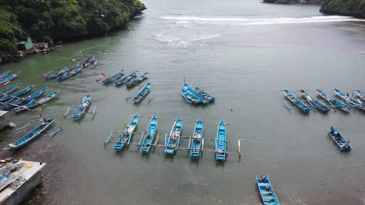 鸟瞰印尼泻湖海滩上的传统船只视频素材