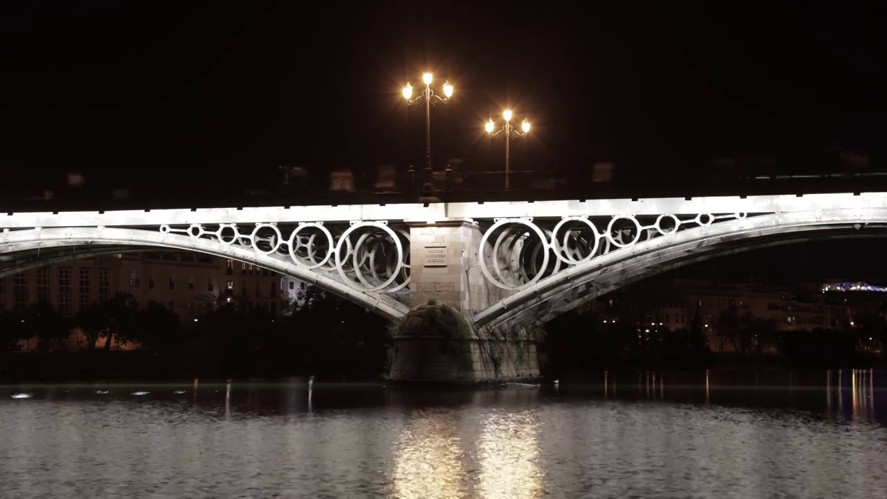 西班牙塞维利亚的特里亚纳大桥的夜景。近距离视频下载