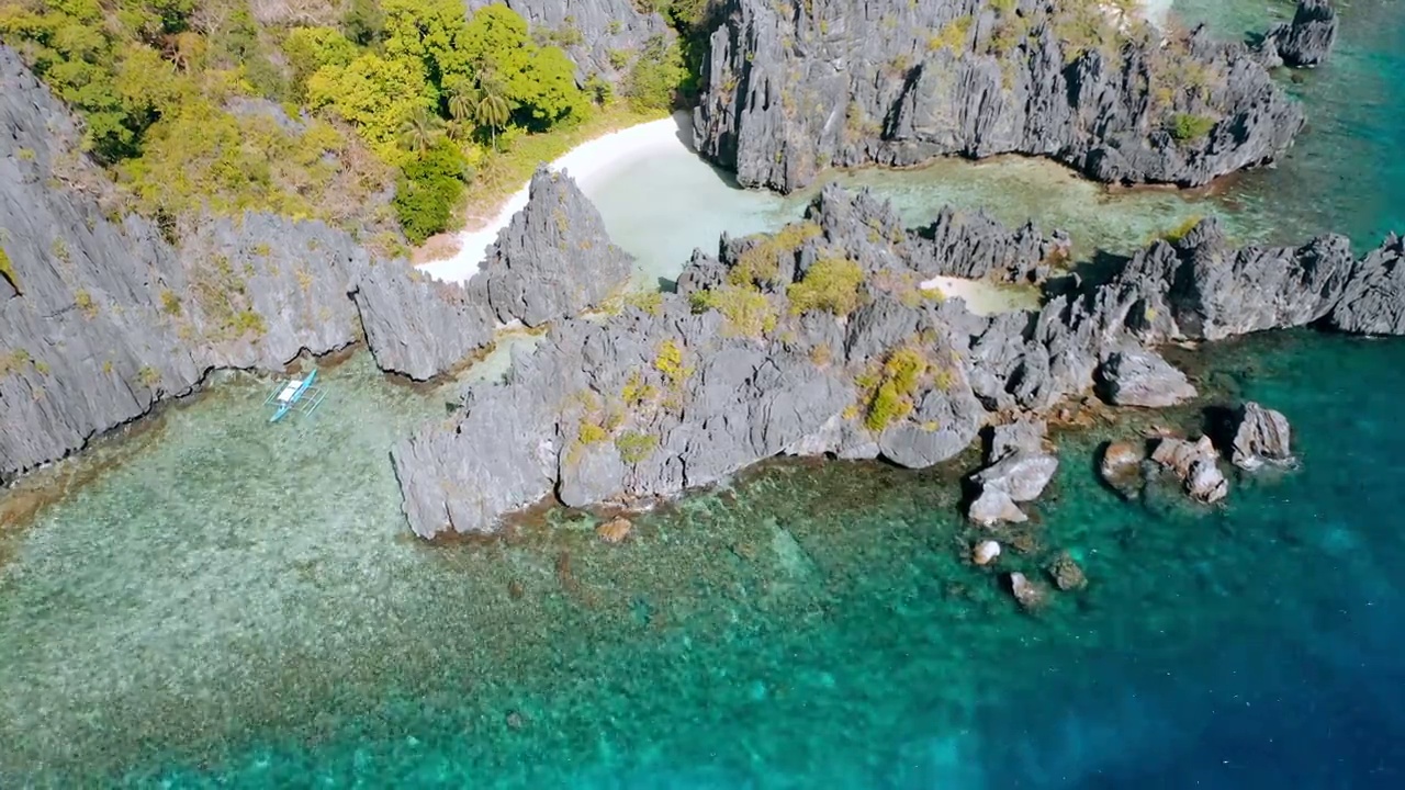 无人机在菲律宾巴拉望岛El Nido的Matinloc岛的隐藏海滩上观看孤独的旅游船-旅游C路线-热带风景中的天堂泻湖视频素材