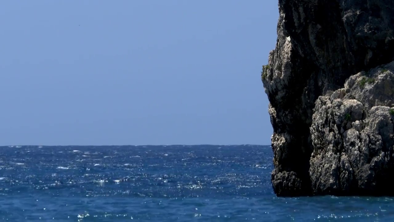 蓝色的海水撞击了从深处升起的贫瘠的岩石视频素材