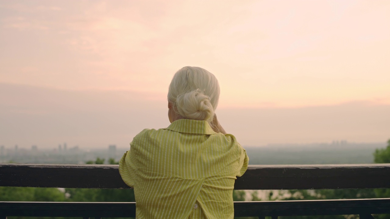 白发苍苍的女子望着城景，怅然老去，悲伤回忆视频素材