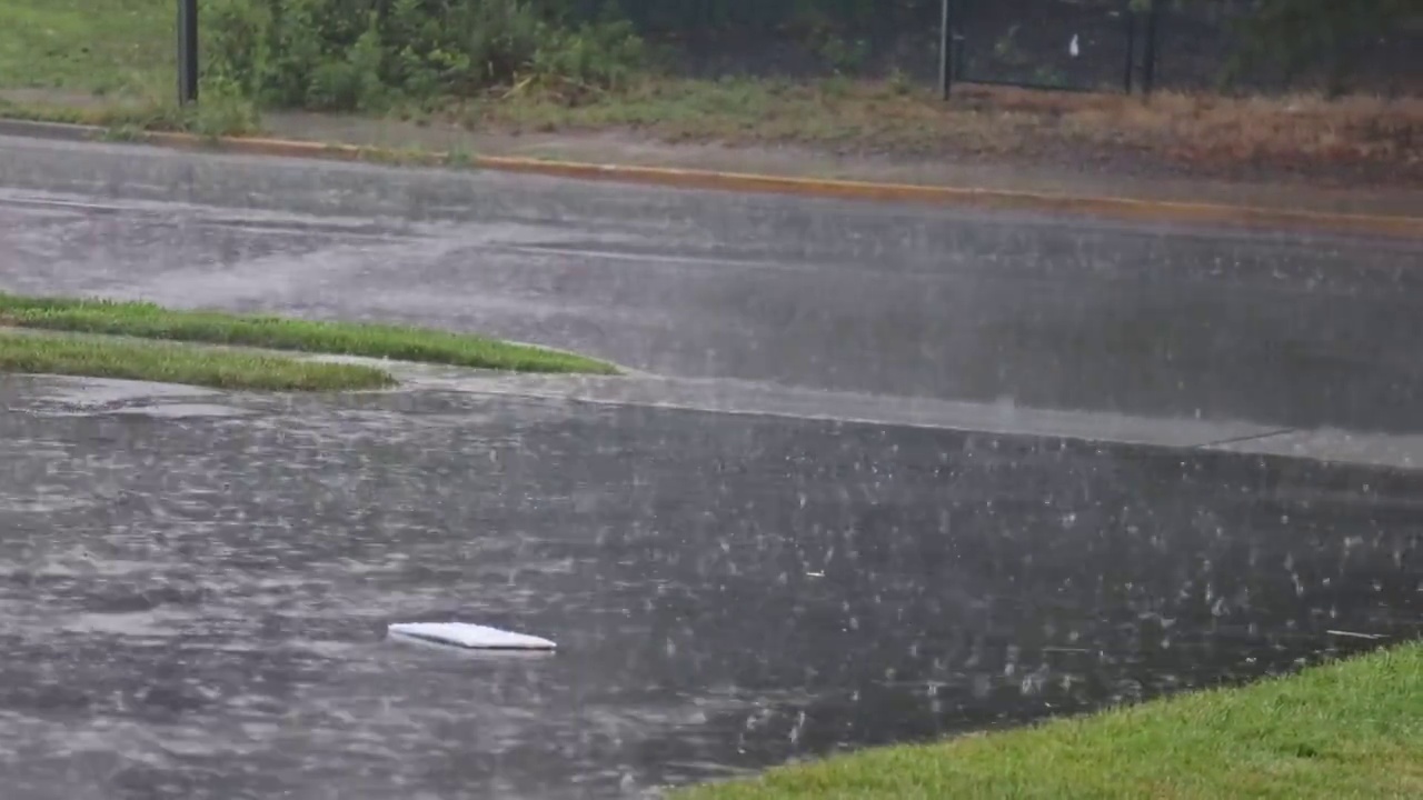 雨水从柏油路上溅起一大滩水花视频素材