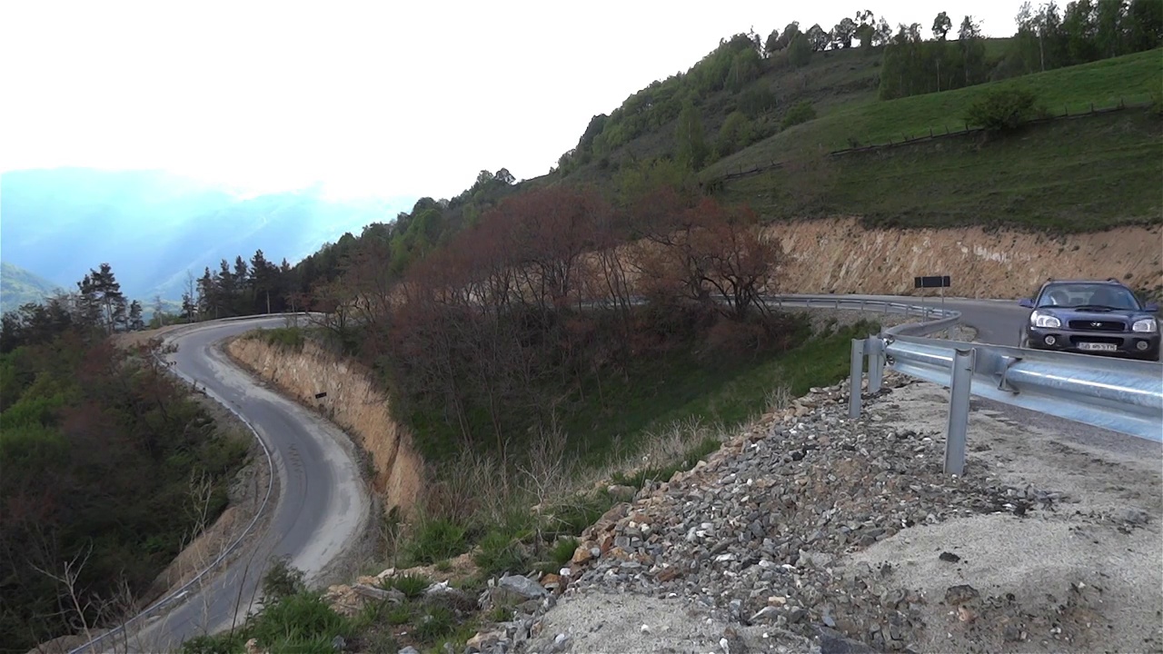 汽车在建在山腰上的有许多弯路的柏油路上行驶视频素材