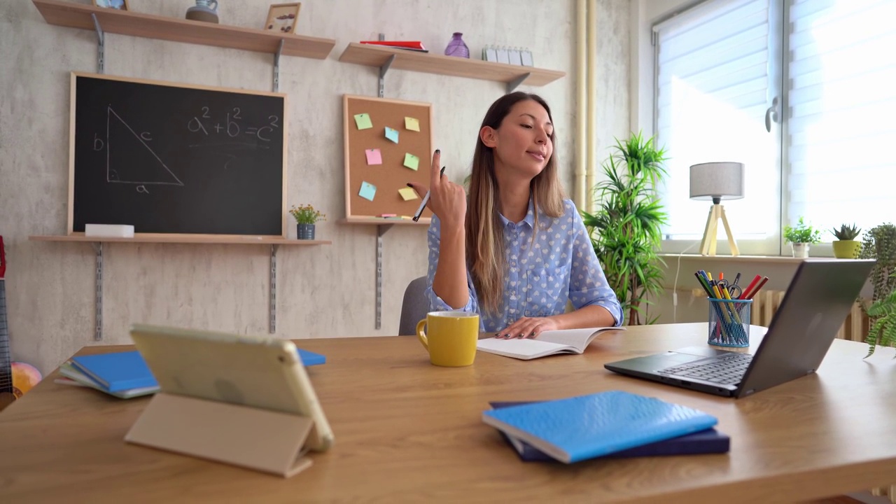 女数学老师在家里用笔记本电脑在线讲课视频素材