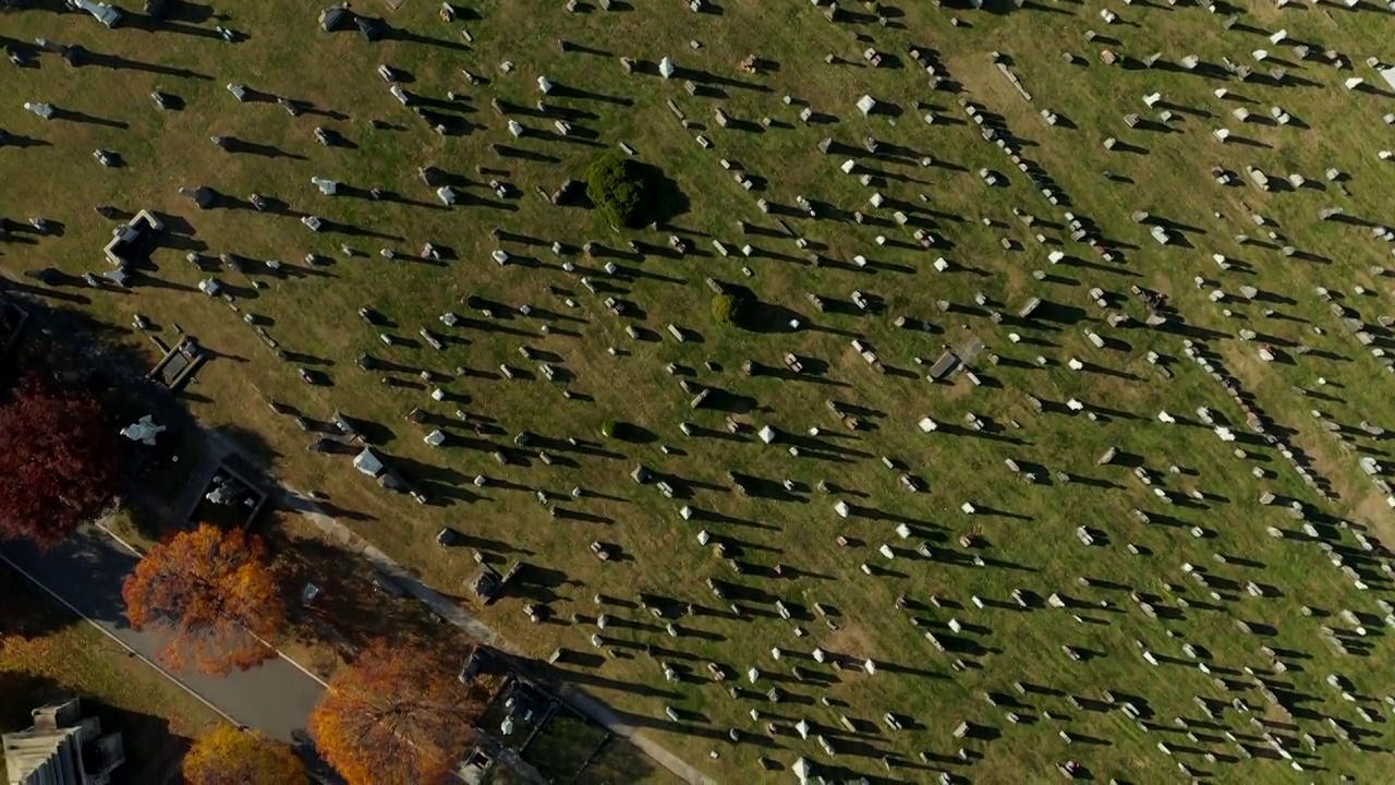 空中鸟瞰历史悠久的大髑髅地公墓。墓碑在绿色的草坪上投下阴影。美国纽约皇后区视频素材