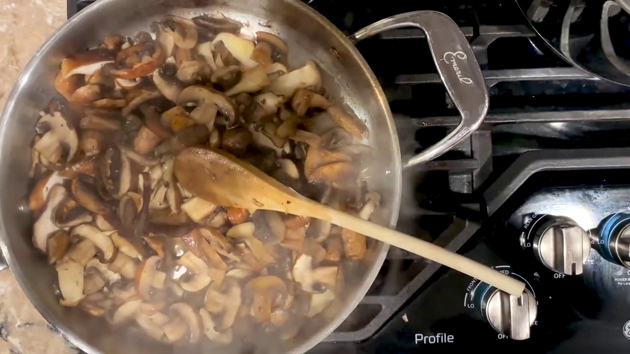 蘑菇的特写sautéing在黄油和橄榄油中视频素材