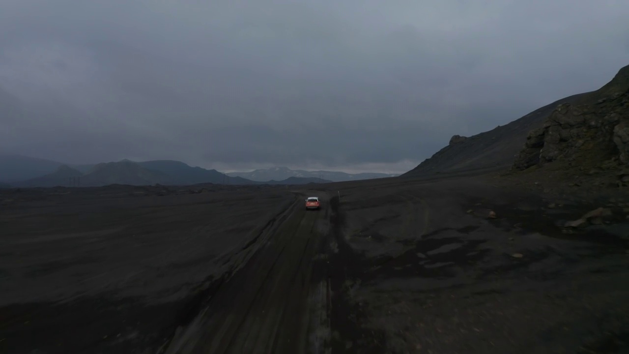 令人惊叹的无人机观看月球表面冰岛景观与车辆驾驶灰尘道路探索高地。一辆四驱汽车在冰岛的泥泞小道上鸟瞰行驶。商业保险视频素材