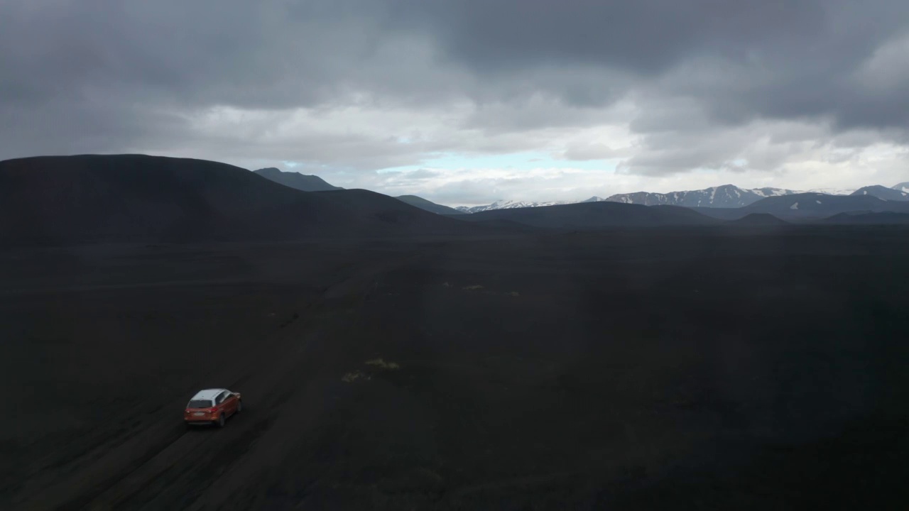 在冰岛Skaftafell国家公园的Lakagigar黑色火山沙漠，无人机观看越野车。鸟眼四驱车在冰岛高地的黑色熔岩地形上超速行驶。冒险和探索视频素材