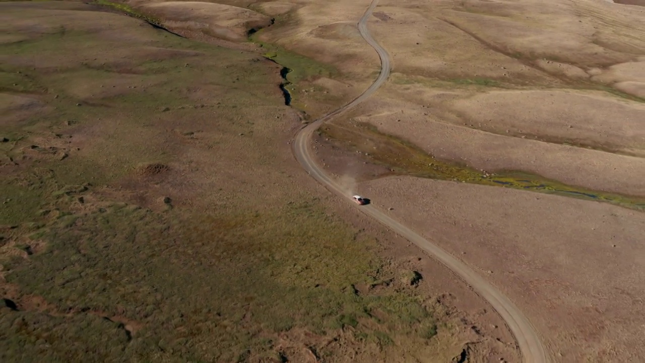 鸟瞰图越野公路4x4汽车行驶在碎石小道上。在冰岛沙漠公路上行驶的越野车的无人机视图。商业银行和保险。自由和流浪癖视频素材