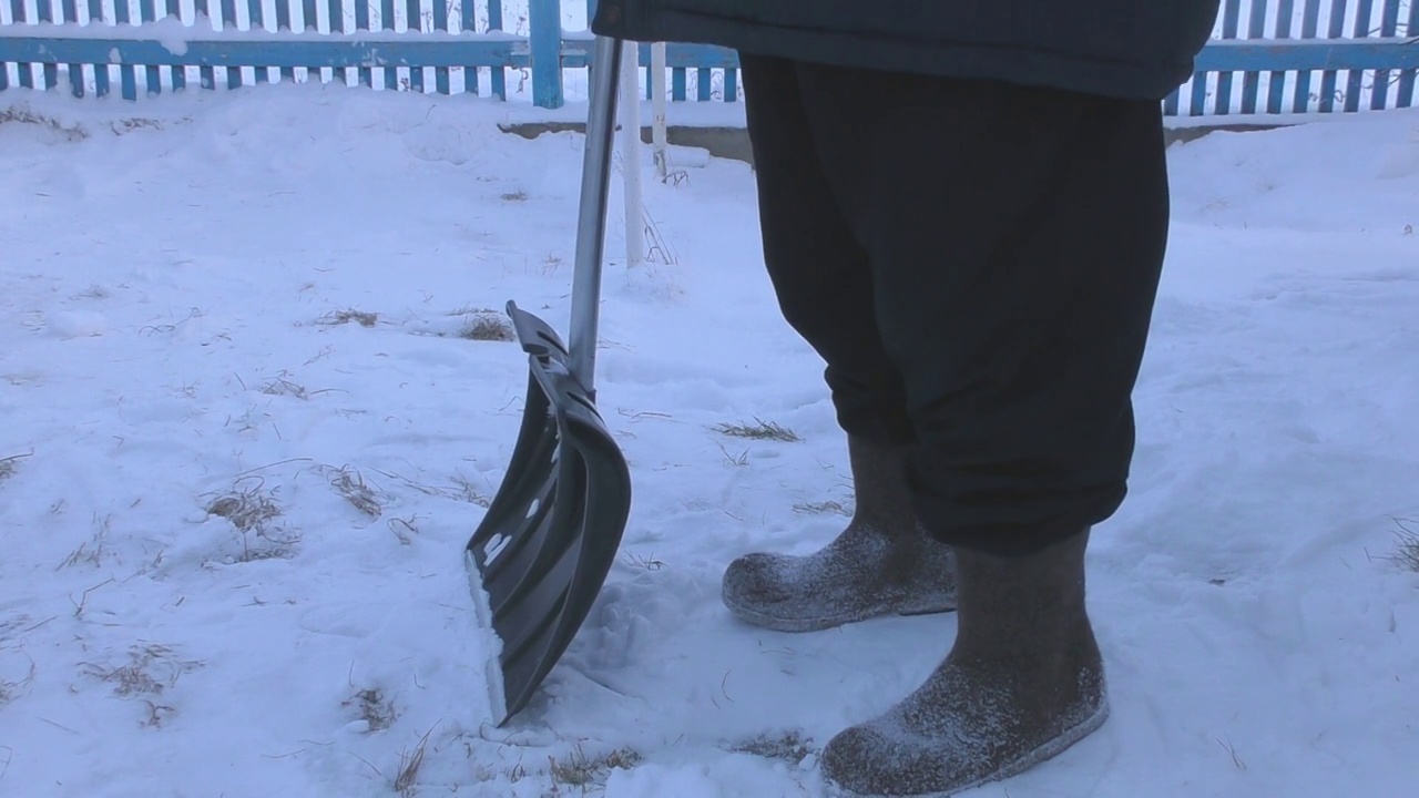 一个男人在街上用铲子铲雪视频素材