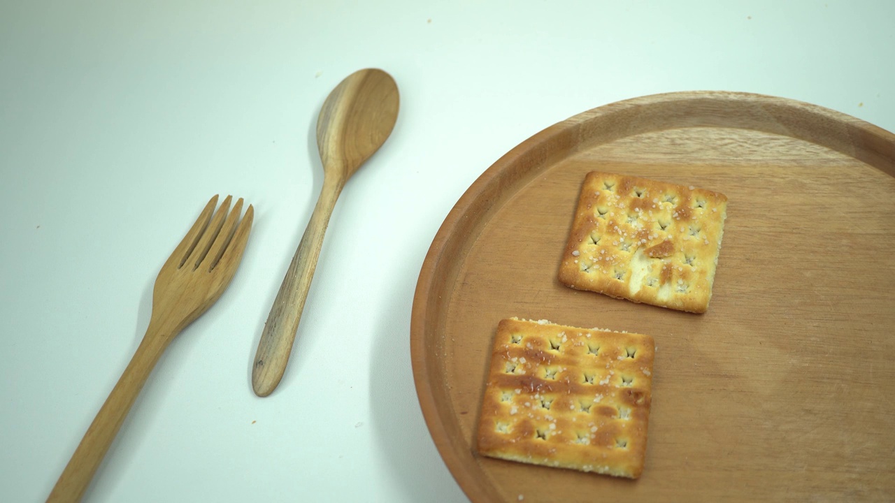 圣诞饼干饼干在木盘，叉子和勺子与白色的背景。视频素材