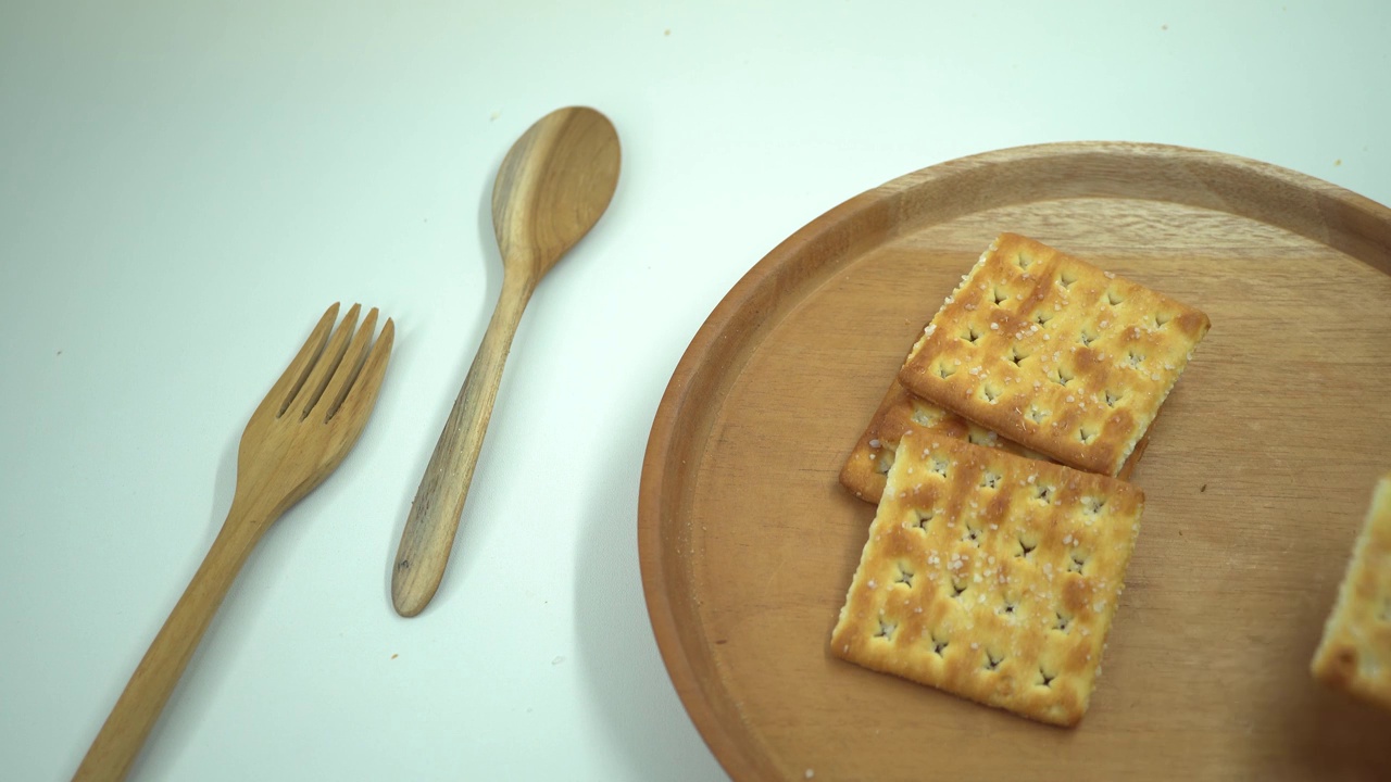 圣诞饼干饼干在木盘，叉子和勺子与白色的背景。视频素材