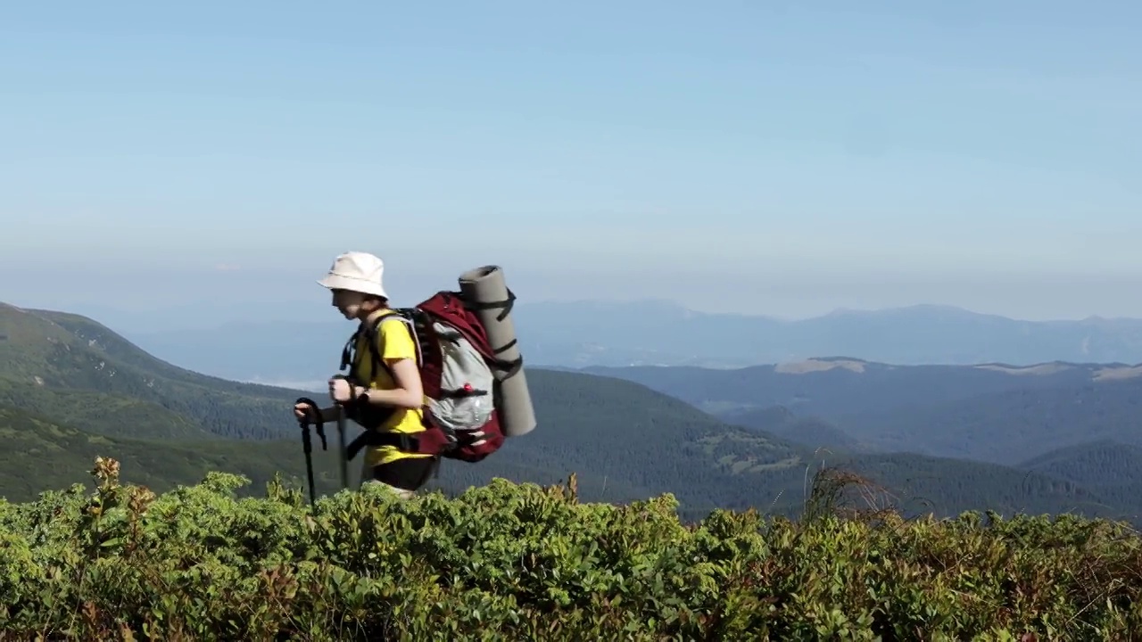 女游客走在山顶上。徒步旅行的人享受生活，风景秀丽，自然风光。暑假探险旅行。背包客徒步旅行高山夏季徒步旅行视频素材