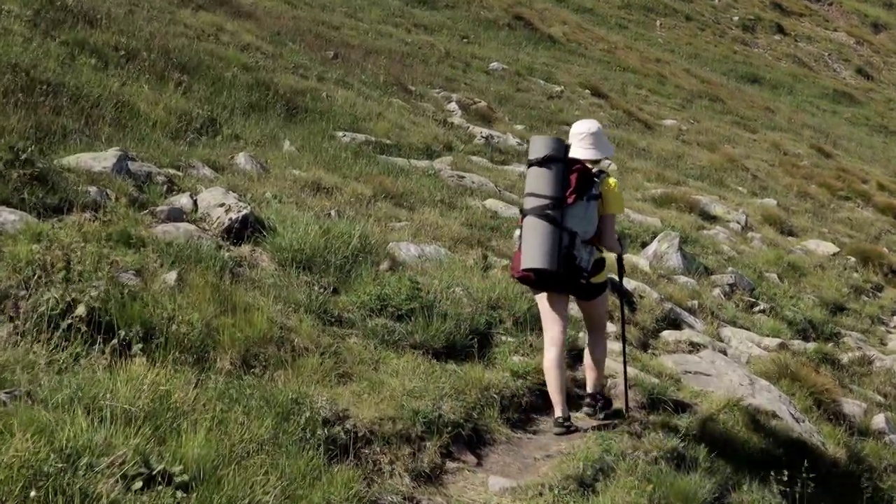 女游客走在山顶上。徒步旅行的人享受生活，风景秀丽，自然风光。暑假探险旅行。背包客徒步旅行高山夏季徒步旅行视频素材